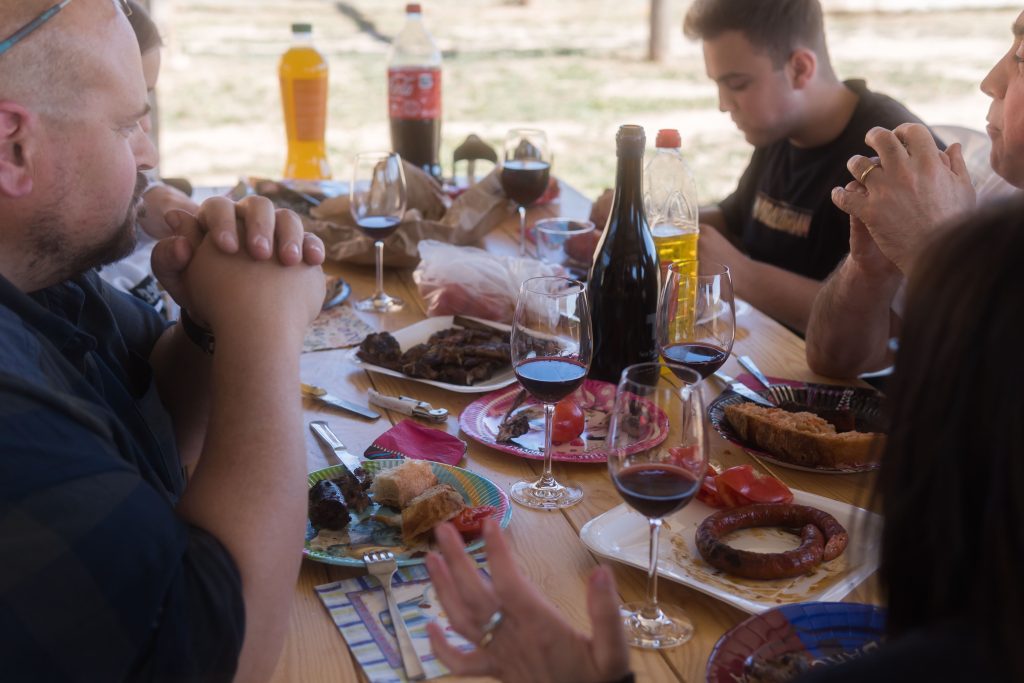 taula amb gent menjant pa i embotits